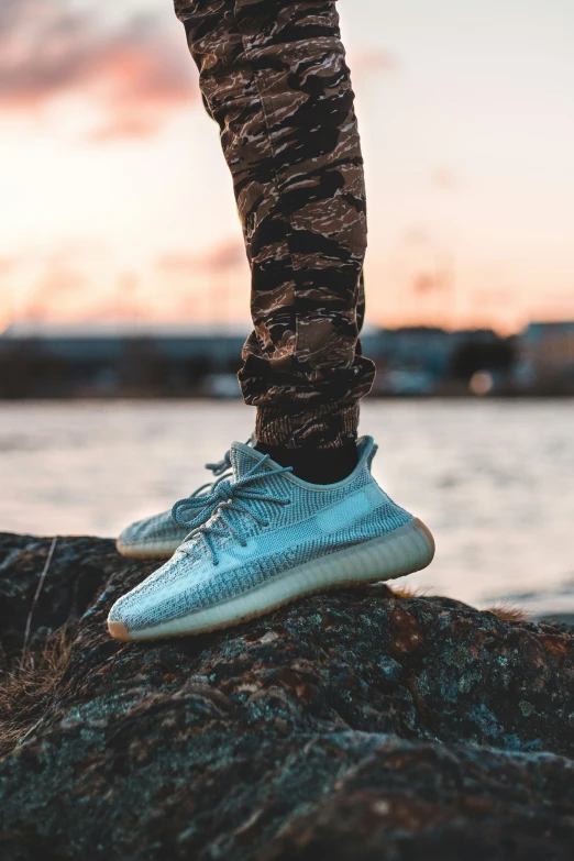 someone standing on a rock wearing sneakers and jeans