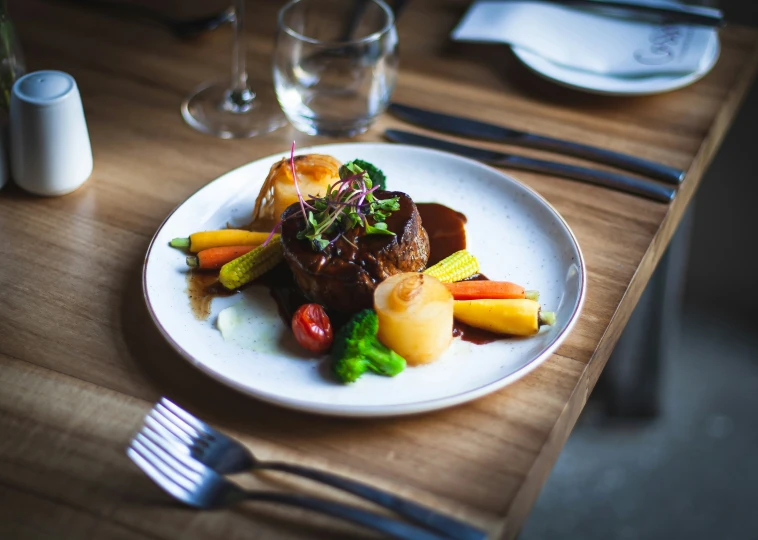 plate of food on table with utensils and glassware