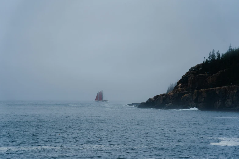 a boat is on the ocean during a gray and misty day