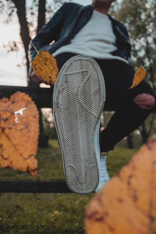 the upper half of an object that appears to be falling apart and a persons foot resting in it