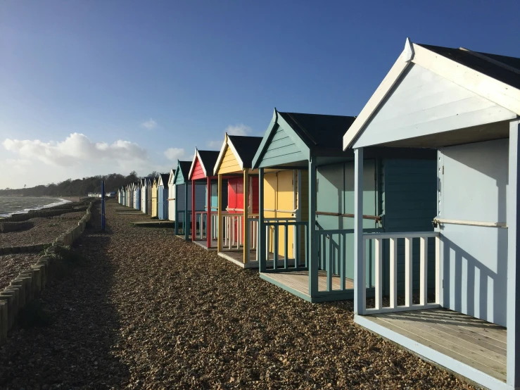 colorful beach huts line the shoreline on a clear day