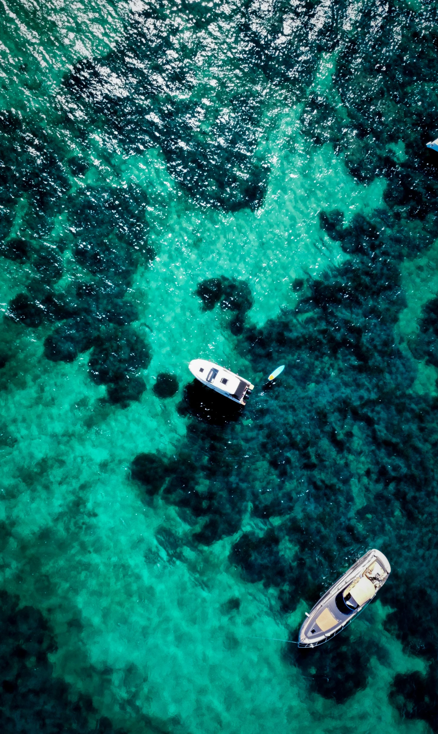 two small boats in the water near rocks