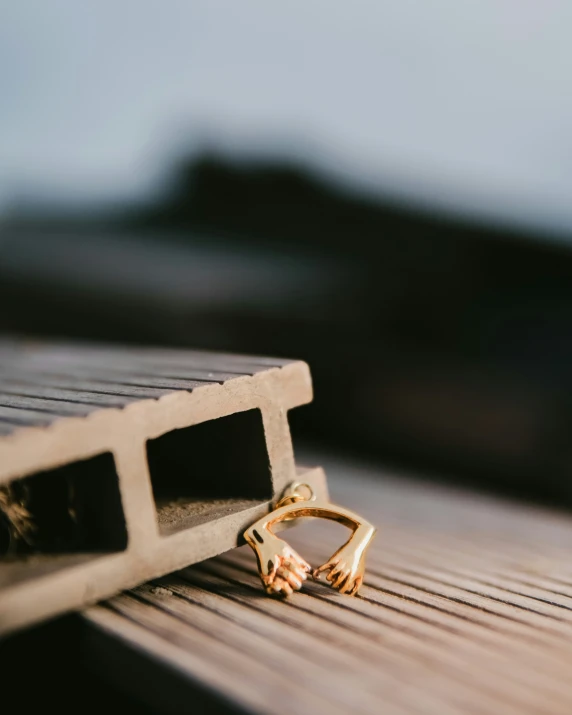 a closeup of a pair of gold rings on a piece of wood