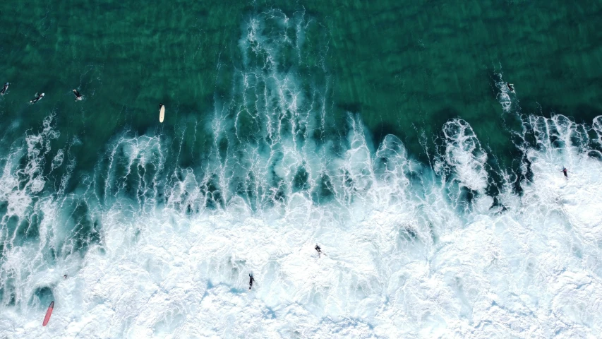an aerial s of waves crashing onto a rocky shore