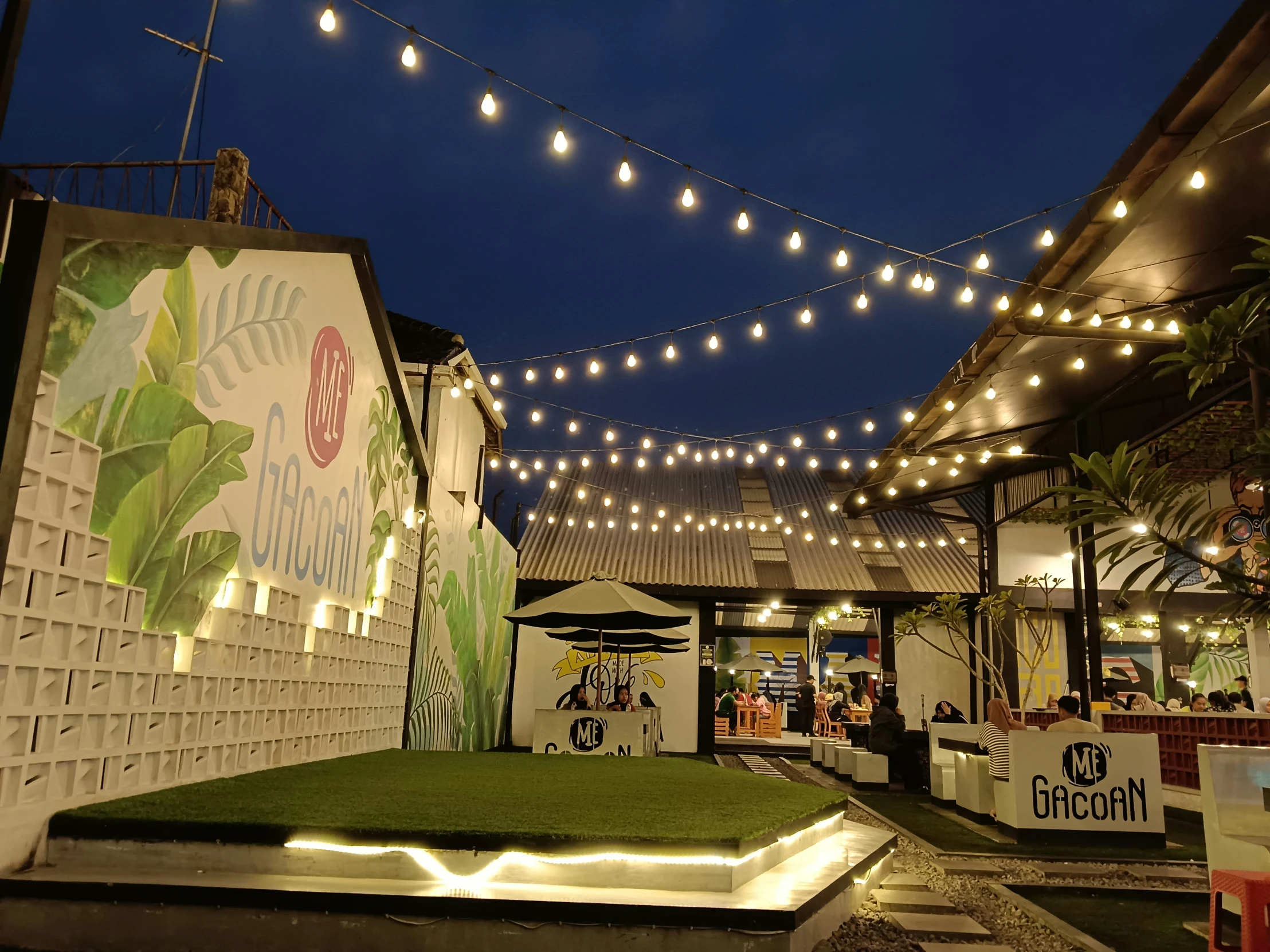 lights strung over a building and a grass area