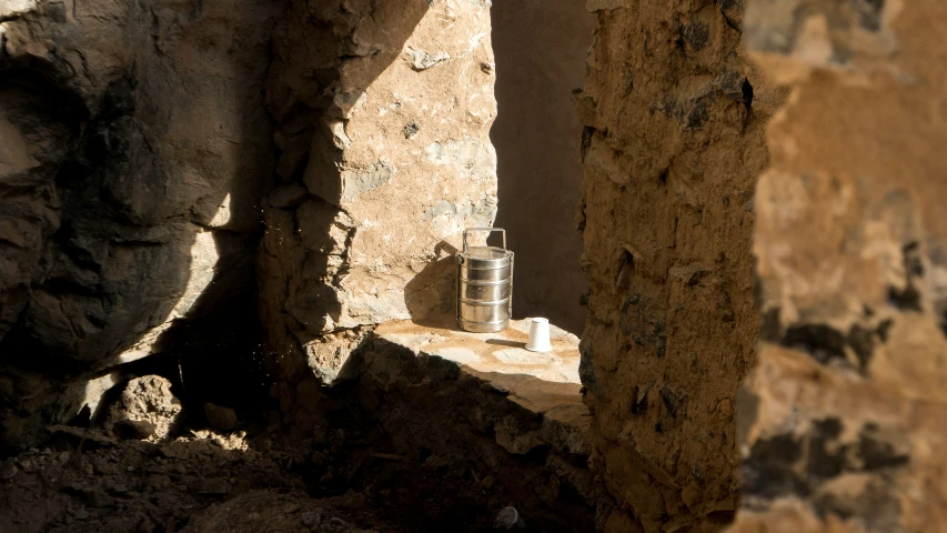 a small can sits in the middle of a stone building