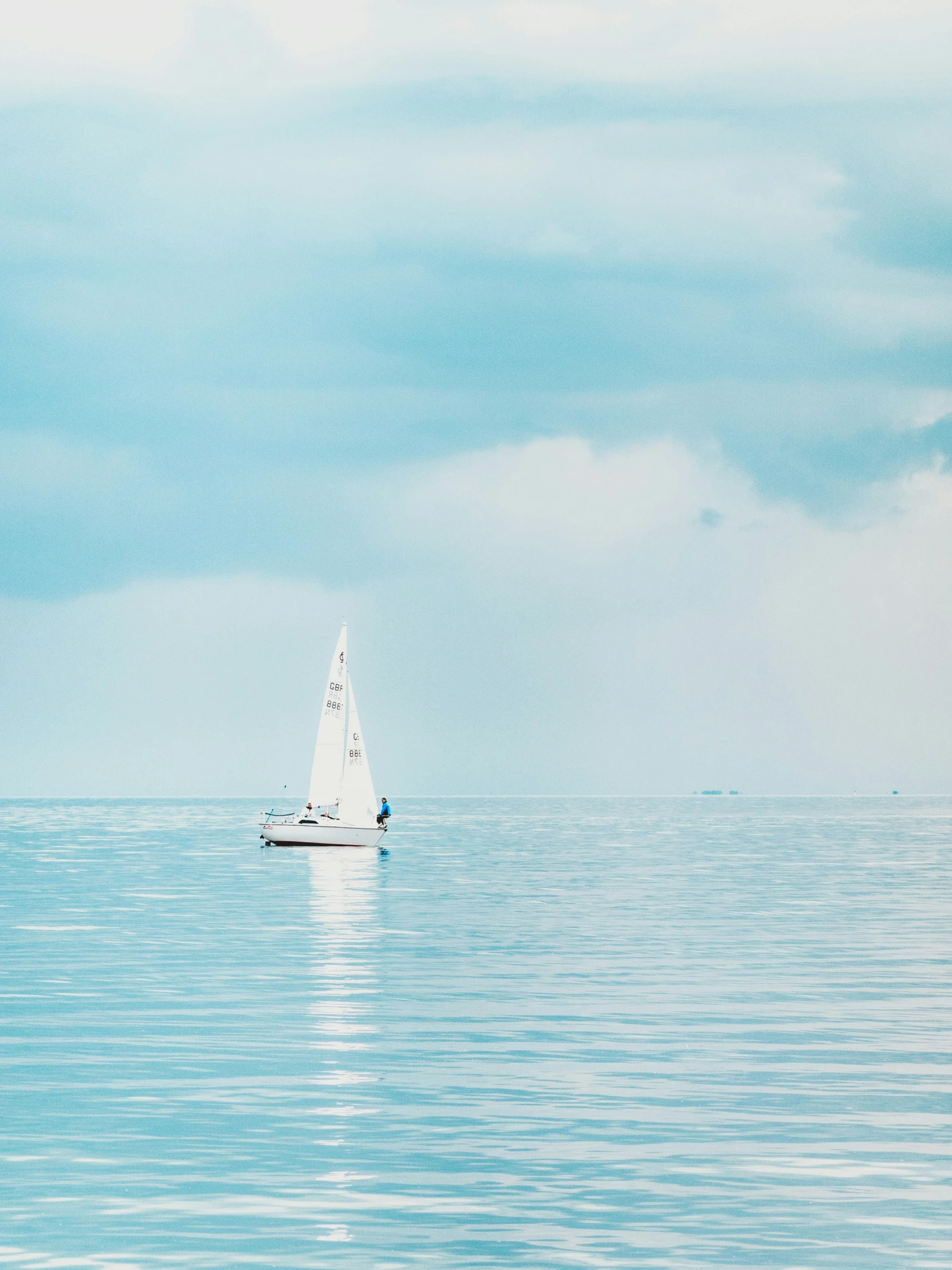 a white sailboat on a body of water