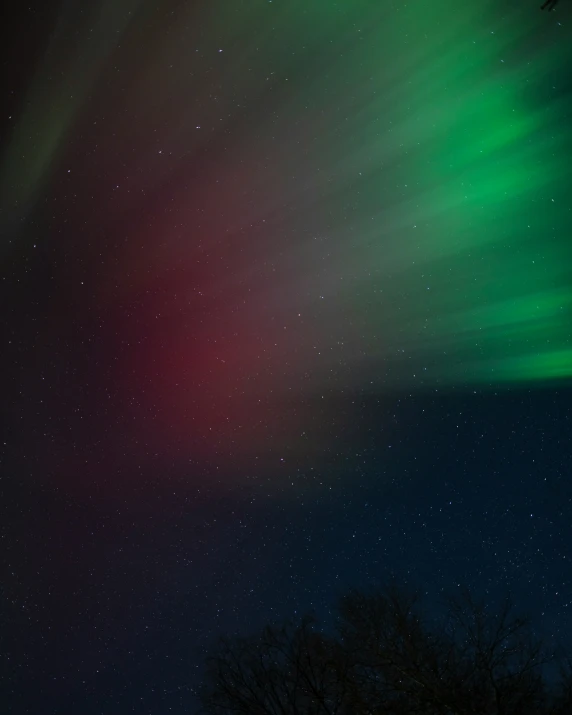 a bright green and red light is in the night sky