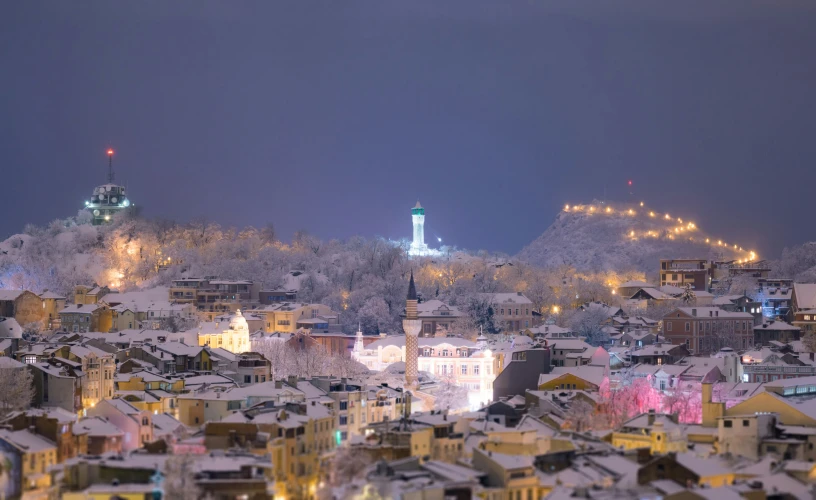 snow covers buildings near a city at night