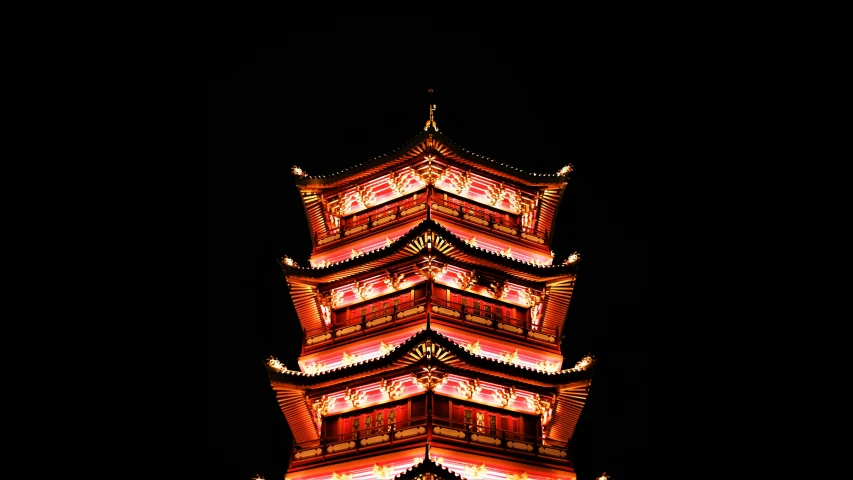 a tall tower at night with people walking around