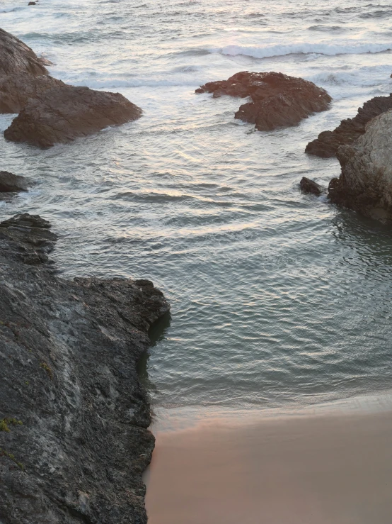 a beach area with a body of water and rock formations