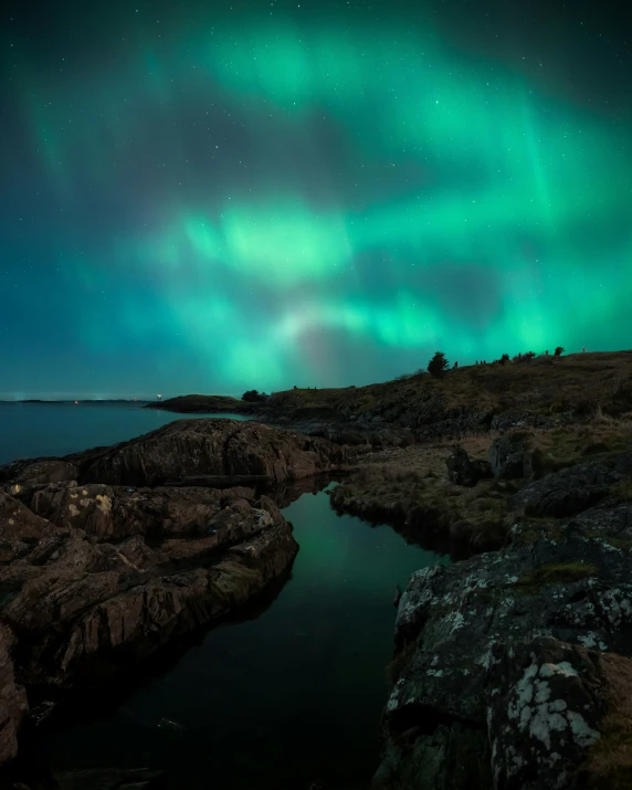 an aurora bored sky over water and rocks