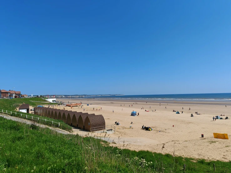 a group of people are playing in the sand at a beach