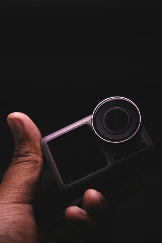 the hand of a person holding a small device