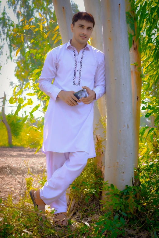 a man in white is standing next to some trees