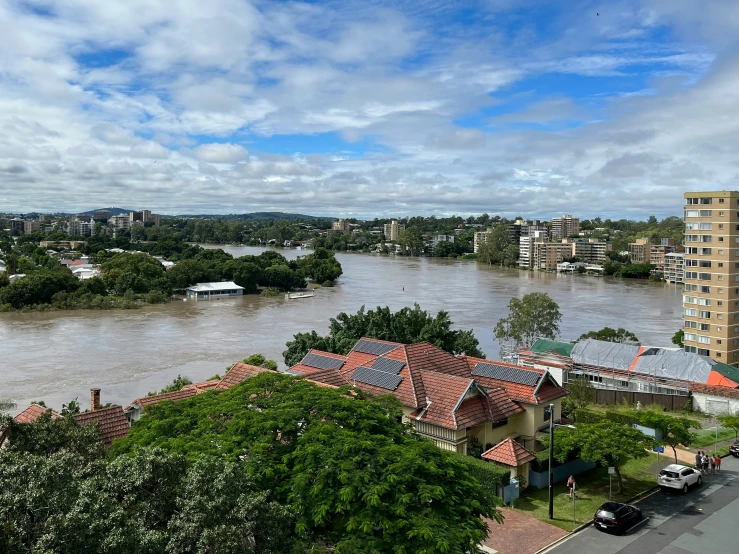 some houses by the water under a cloudy sky