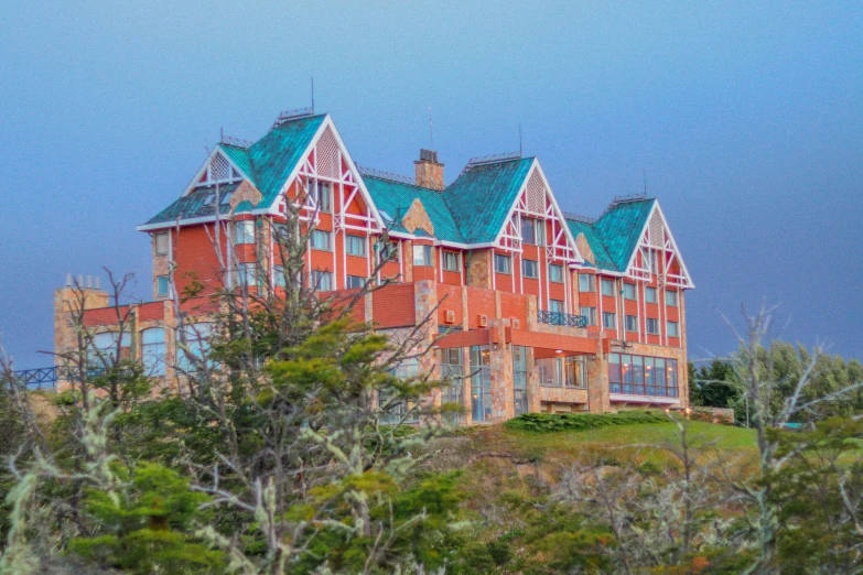 a tall building surrounded by trees on a hillside