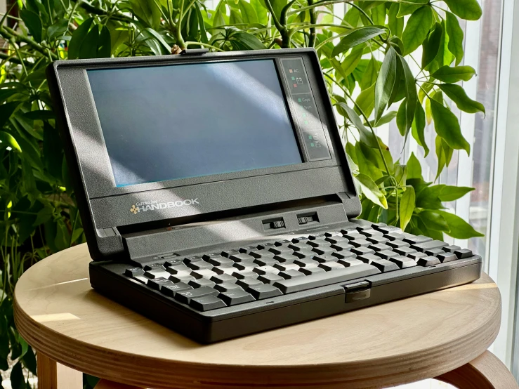 a laptop sitting on top of a wooden table