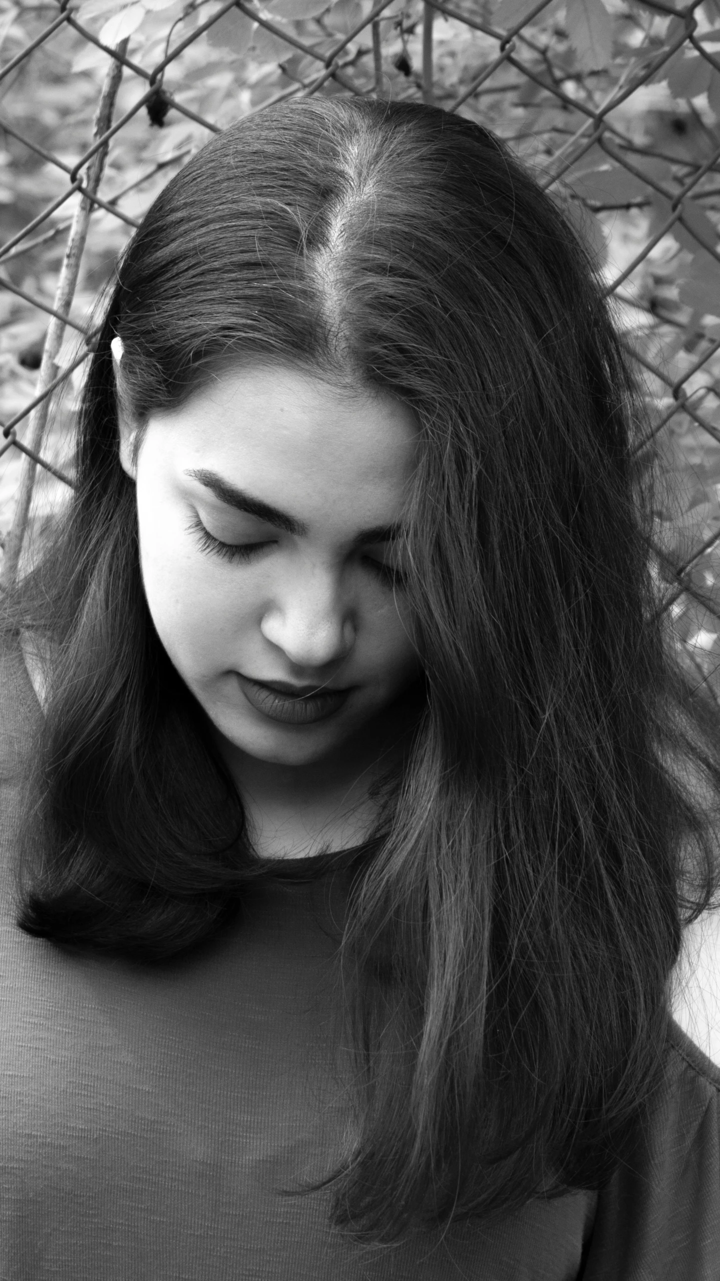 a young woman looks down at her phone