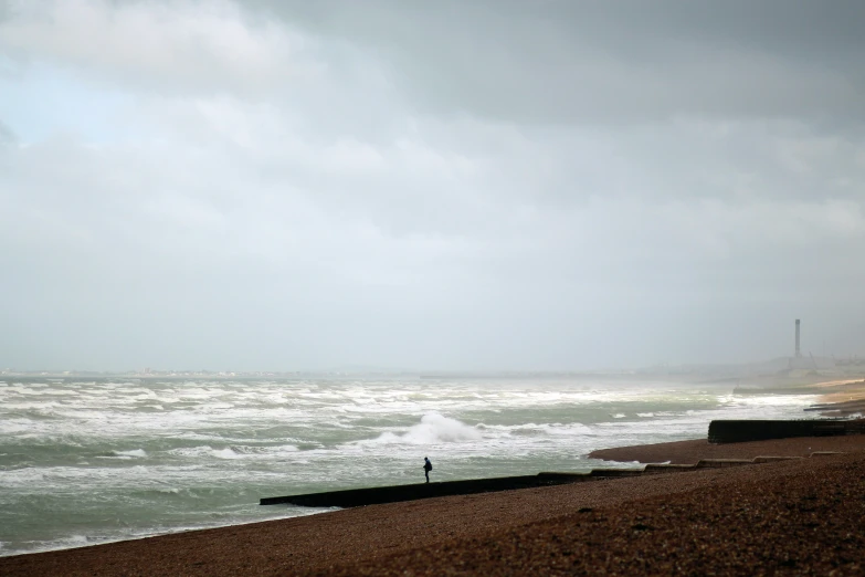 a person walking along a beach on a misty day