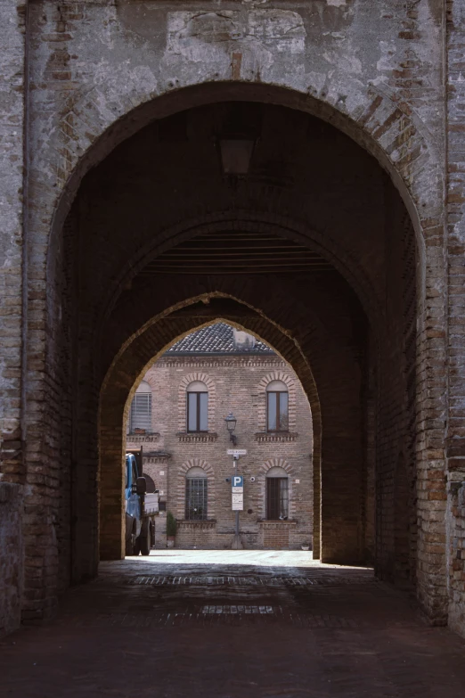 an arch in a brick wall with a clock on it