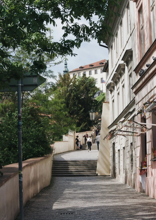 a small cobblestone street with steps and trees on either side