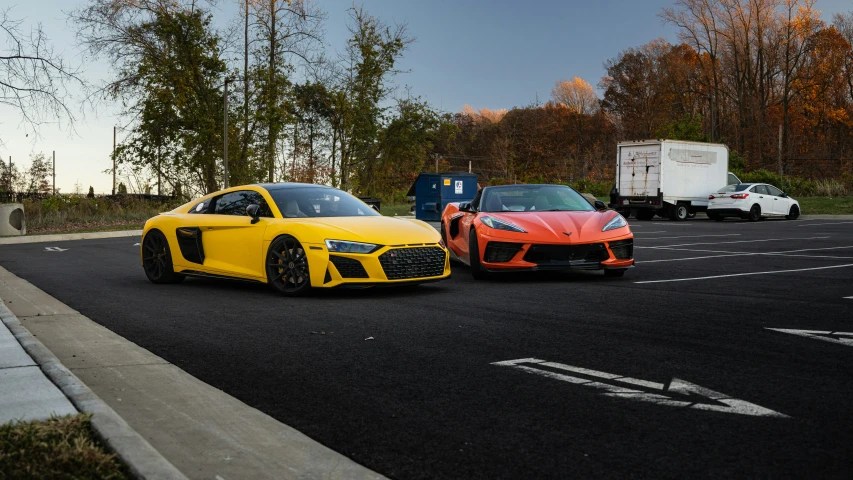 two cars sitting in a parking space on the road