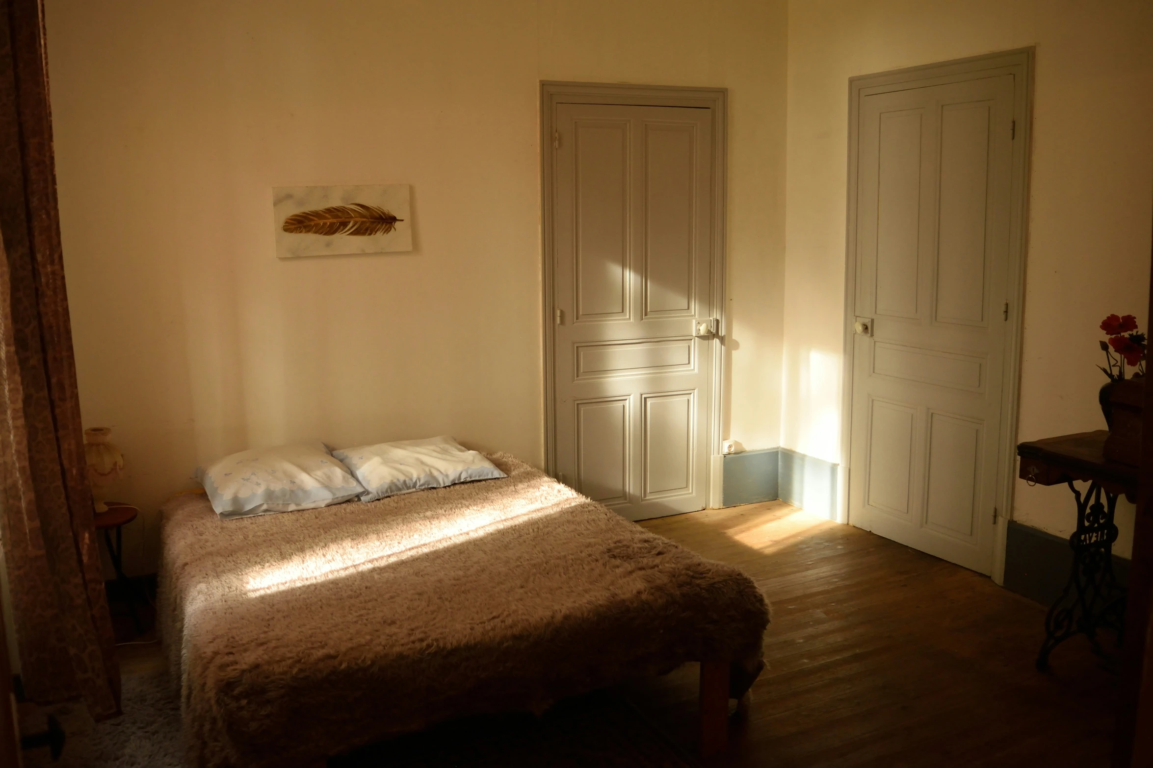 a bedroom with a neatly made bed and a painting