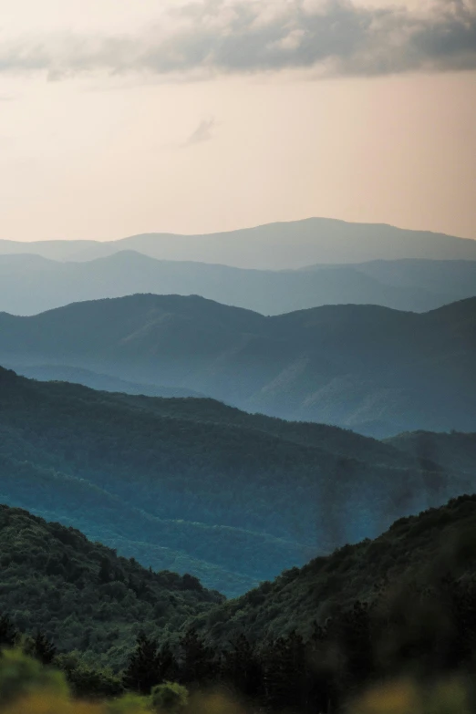 a landscape view of mountain tops and forests in the sky