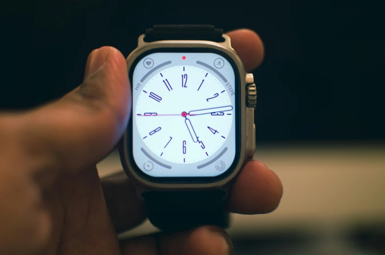 a hand is holding a smart watch with a clock face on