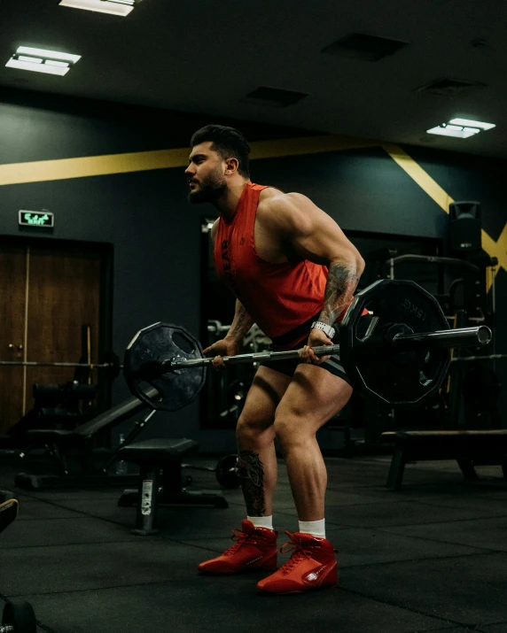 a man in red is doing exercises on a barbell