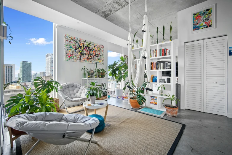 a living room with large potted plants on the wall