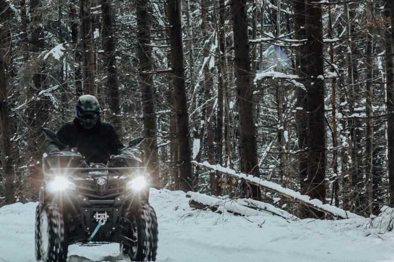 man riding a four wheeler in the snow on its side