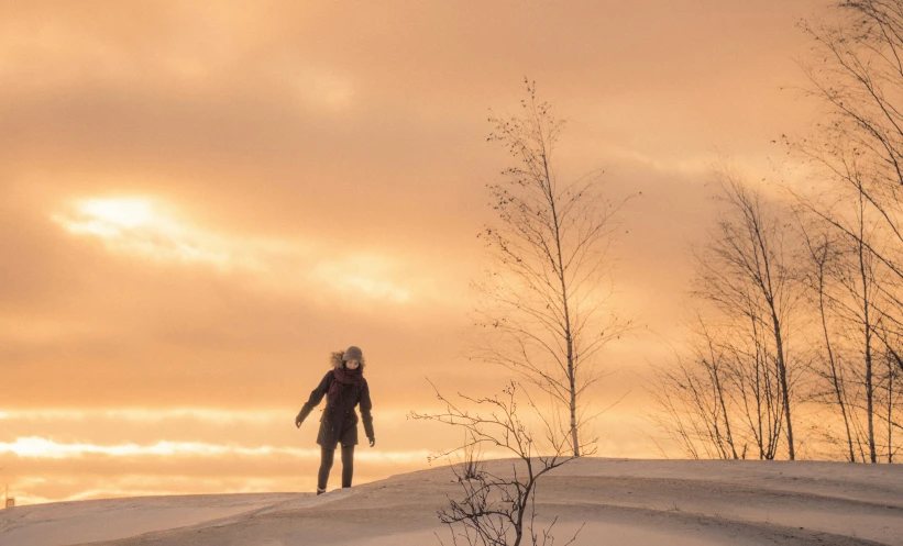 a woman is standing alone in the snow