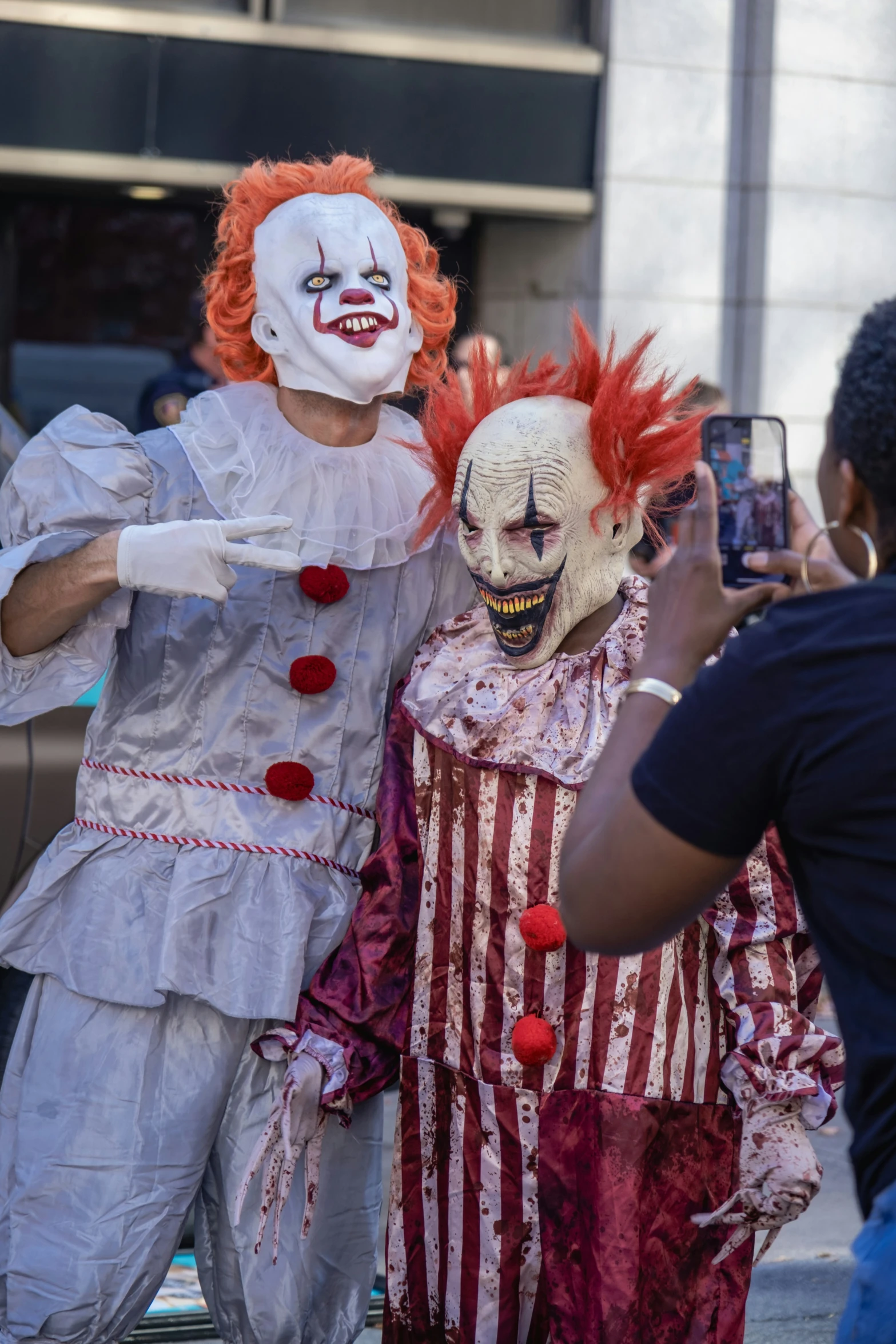 two people wearing clown make faces, one of which is taking a po