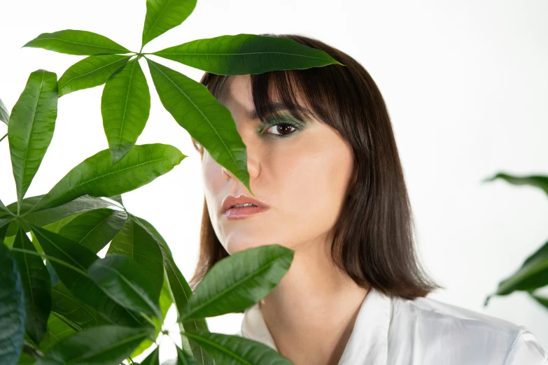 the young woman is hiding behind the plants