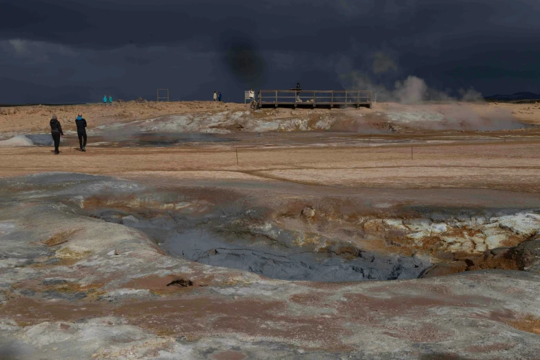 some dark clouds and some black smoke on a beach