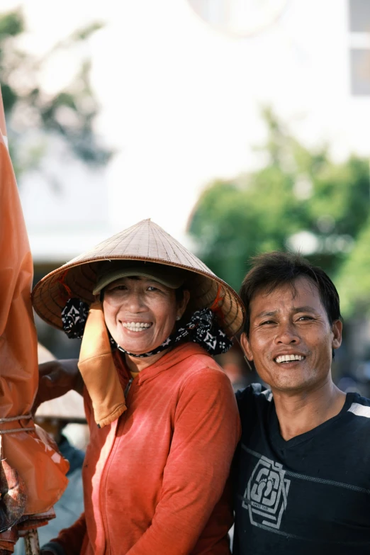 a man standing next to a woman in a hat