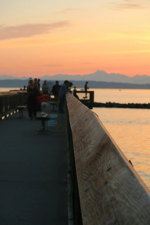 a wooden plank in front of water with mountains in the distance