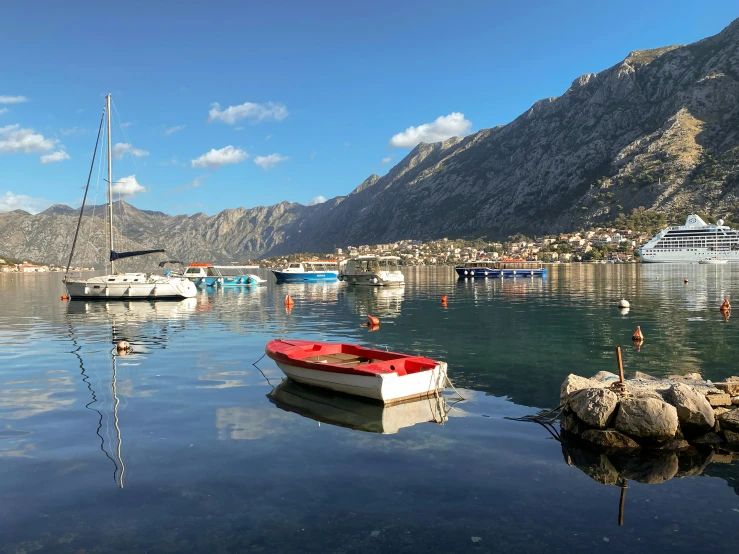 a small red boat is docked next to the dock