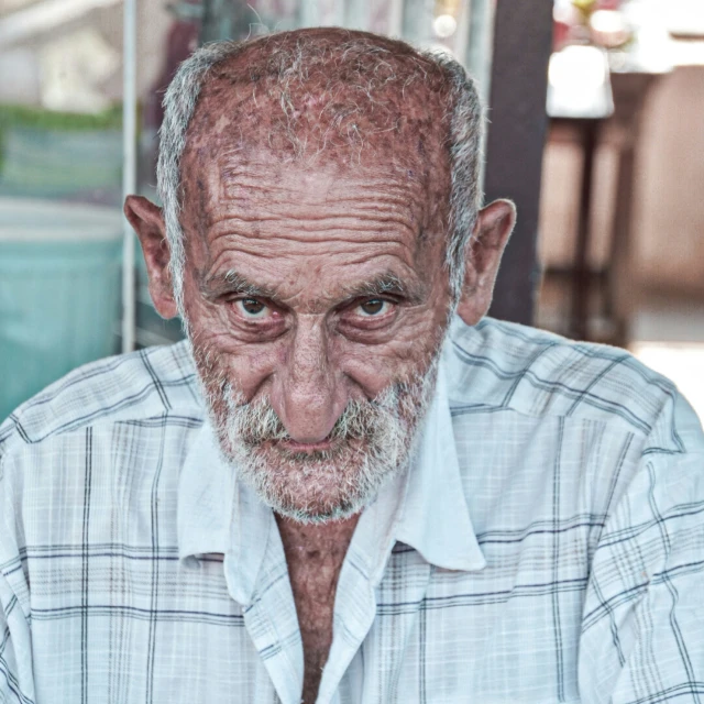 old man with hair shaved with street scene in the background