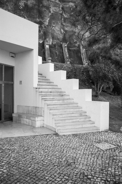 two white stairs with black door and window on brick sidewalk