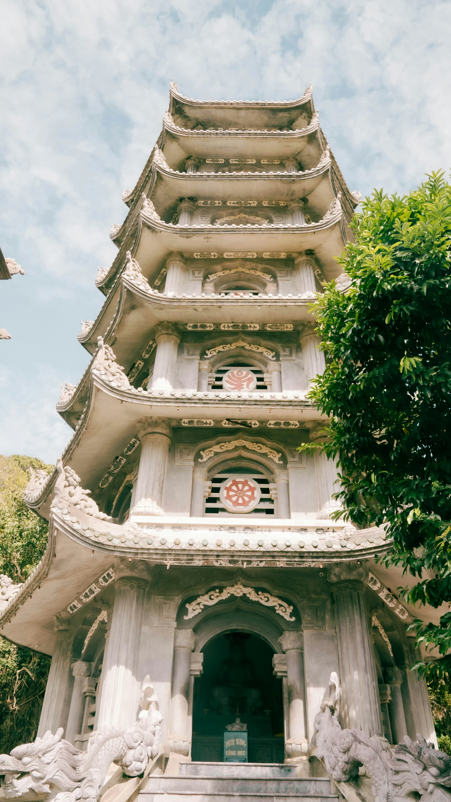 the pagoda has statues at its base around the clock