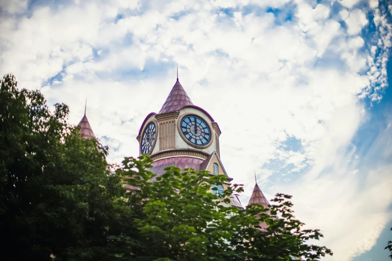 the view of a clock tower from behind some trees