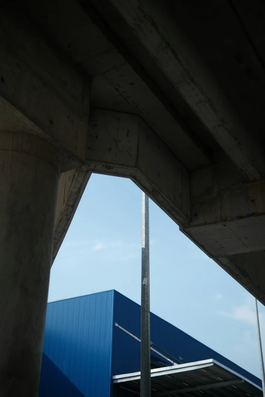 a tall pole sits under the bridge that's underpass