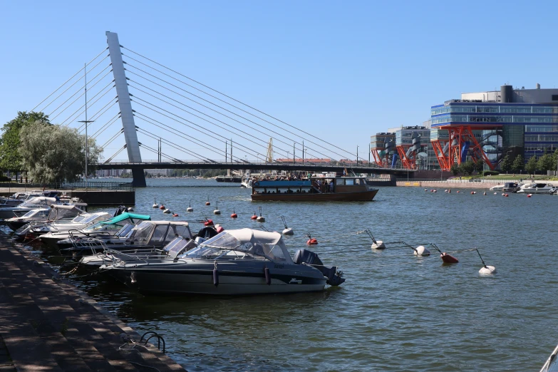 boats parked in front of a pier with people on them