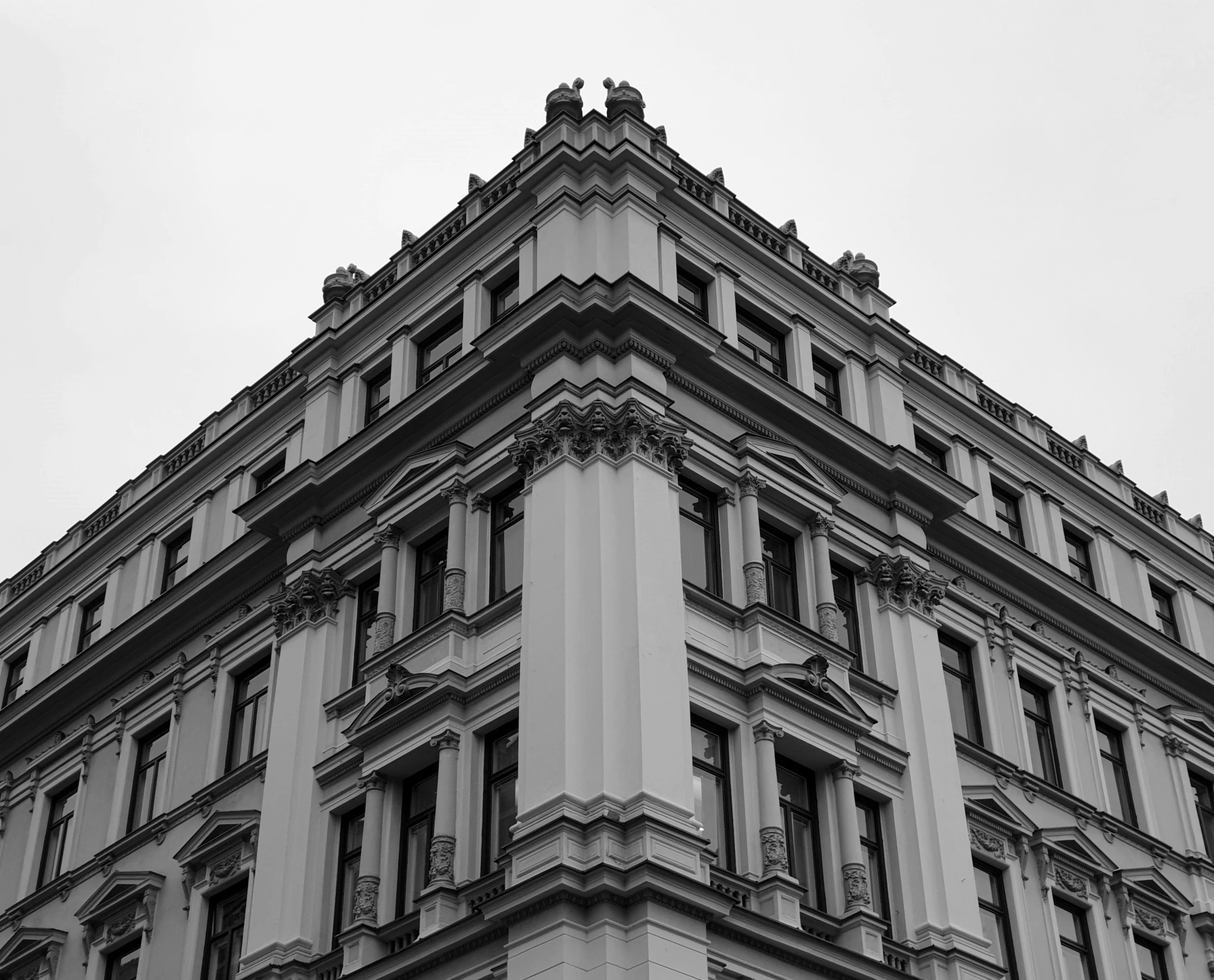 the corner of a gray and white building on a clear day