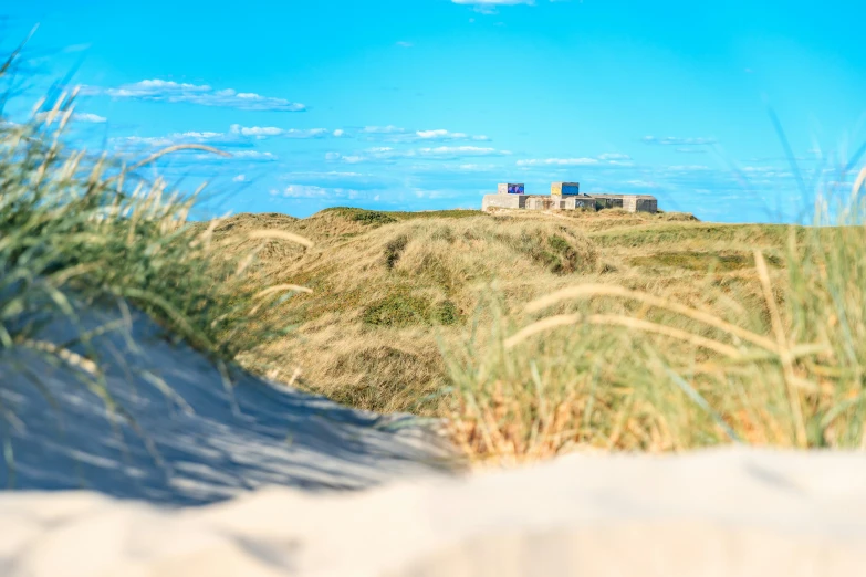 a beach dune that has grass on the top of it