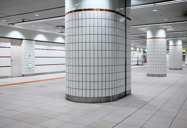 a long line of white tile inside an empty subway