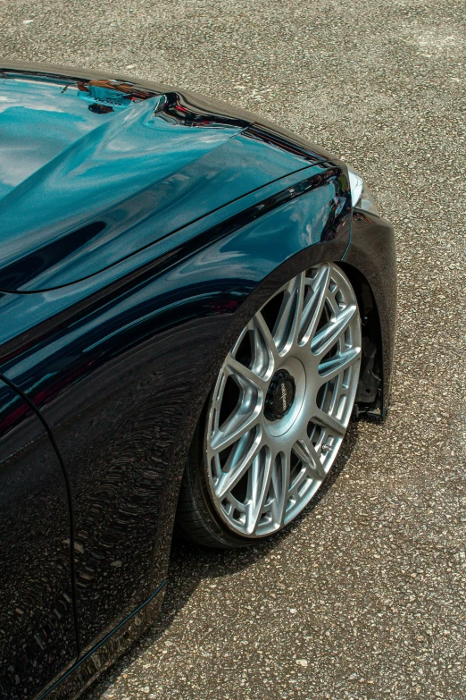 a close up view of a blue car with a chrome spoke